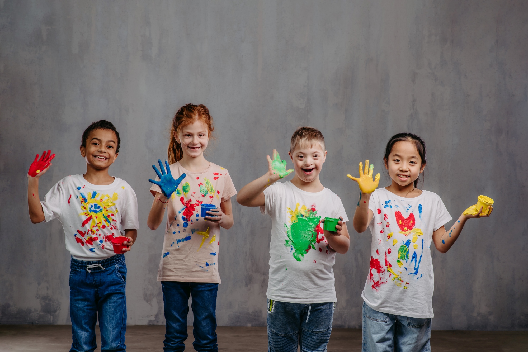 vier Kinder mit Fingerfarben an den Händen