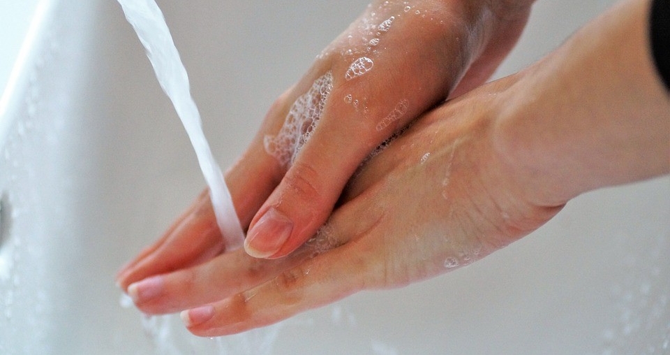 Zwei Hände die an einem Waschbecken gewaschen werden