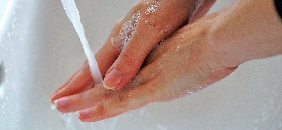 Zwei Hände die an einem Waschbecken gewaschen werden