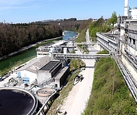 Industriekläranlage Bildmitte Industriekläranlage mit Becken vorne und Gebäuden hinten, rechts Industriegebäude, links Fluss und Wald