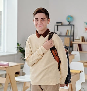 Schulkind mit Rucksack im Klassenzimmer