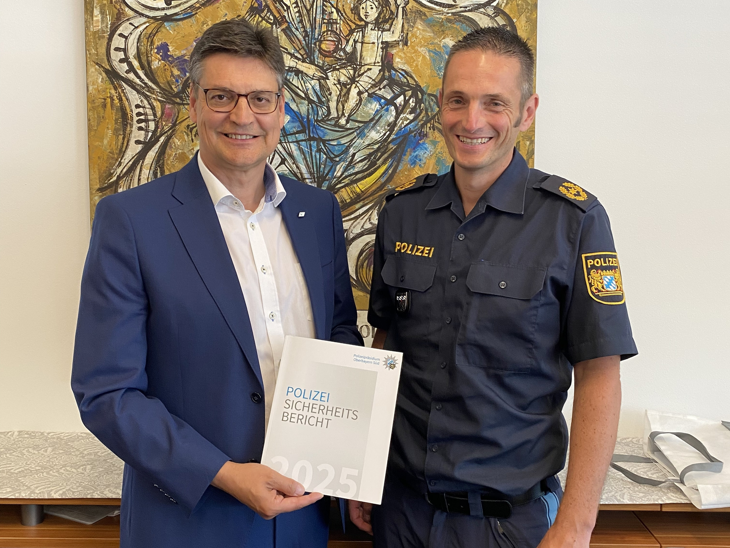 Vize-Polizeipräsident Michael Siefener (rechts) überreicht den Sicherheitsbericht 2025 an Landrat Max Heimerl.