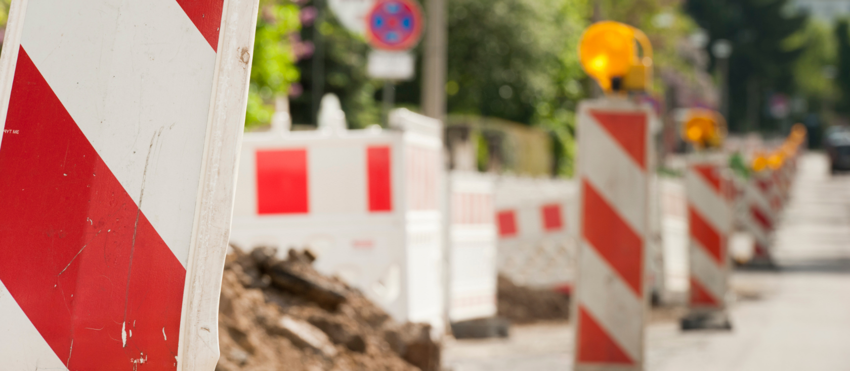 Am Straßenrand aufgereihte Baustellenabsperrungen