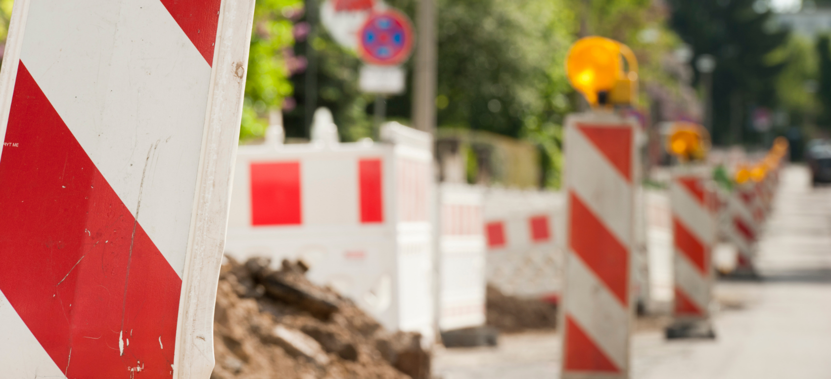 Am Straßenrand aufgereihte Baustellenabsperrungen