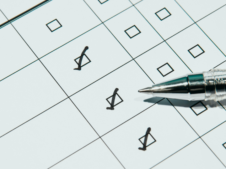 Eine Fragebogen mit drei angekreuzten Kästchen und einem danebenliegenden Stift