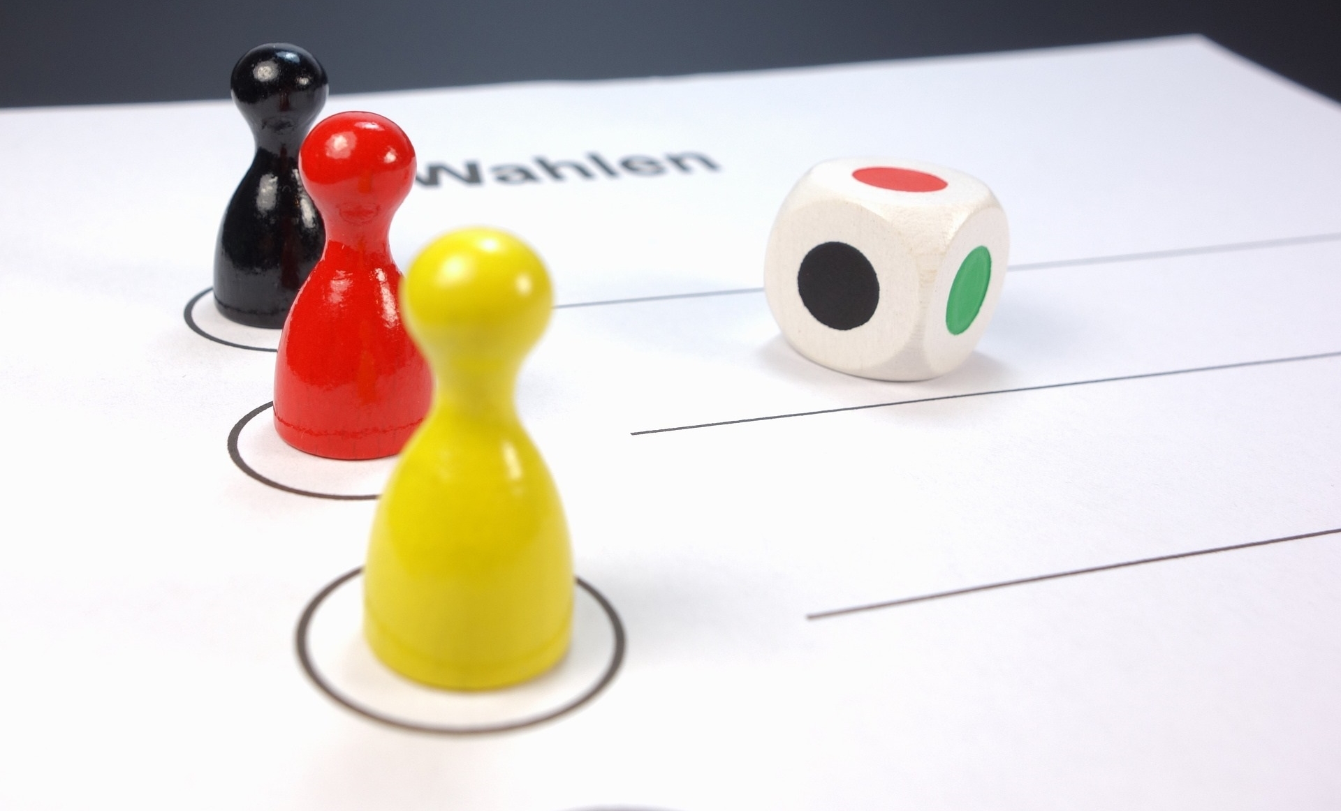 Spielfiguren welche in Deutschlandfarben auf einem Wahlzettel abgebildet sind