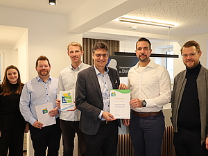 (von links nach rechts): Michaela Linner (Wirtschaftsförderung Landkreis Mühldorf a. Inn), Wirtschaftsförderer Thomas Perzl, Johannes Maier (Partner Dr. Baierlein & Partner), Landrat Max Heimerl, Stephan Kretzschmar (Partner Dr. Baierlein & Partner) und Bürgermeister Michael Hetzl bei der Übergabe der Urkunde zum Umwelt- und Klimapakt Bayern.