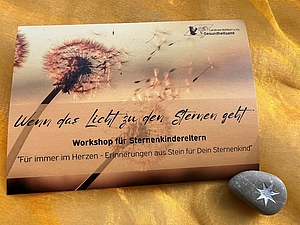 Eine beigefarbene Einladung mit einer Pusteblume im Hintergrund zum Workshop für Sternenkindereltern mit einem Erinnerungsstück aus Stein 