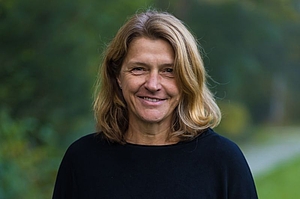 Portrait einer Frau mit blonden, langen Haaren im Freien