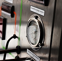 Wärmepumpen-Manometer auf silberner Anlage mit Kabeln und Schläuchen