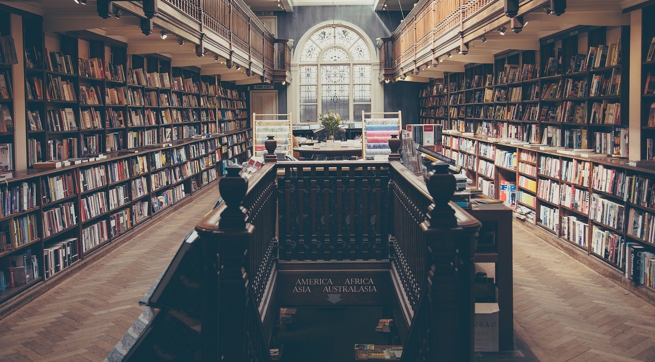 Bibliothek von innen mit vielen Büchern und einer Treppe in der Mitte 