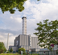 Industrieanlage Chemieanlage mit Schornstein hinter Bäumen