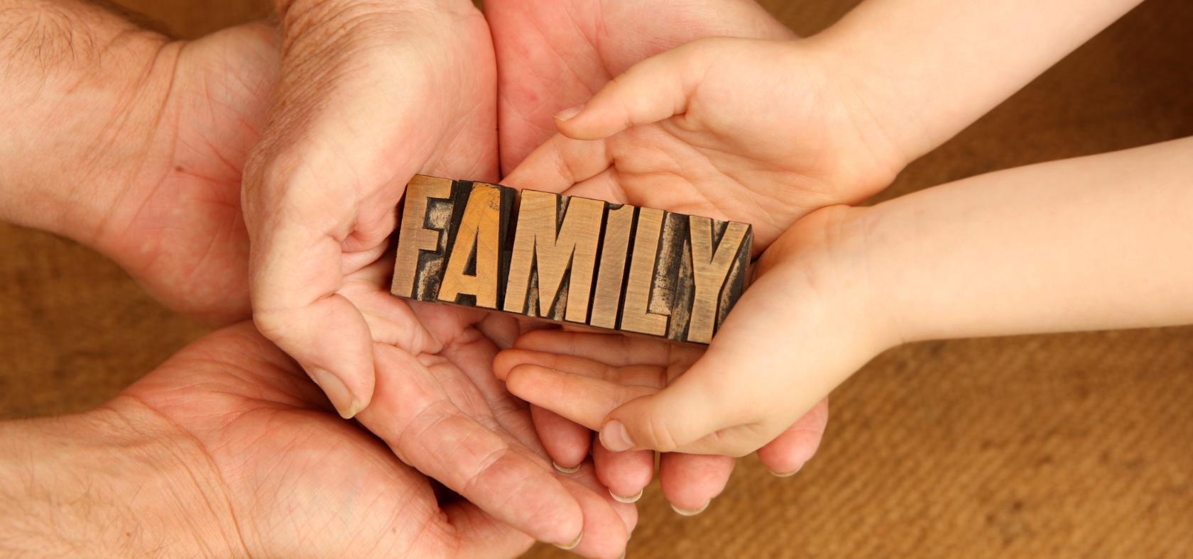 Verschiedene Hände die das Wort "FAMILY" halten