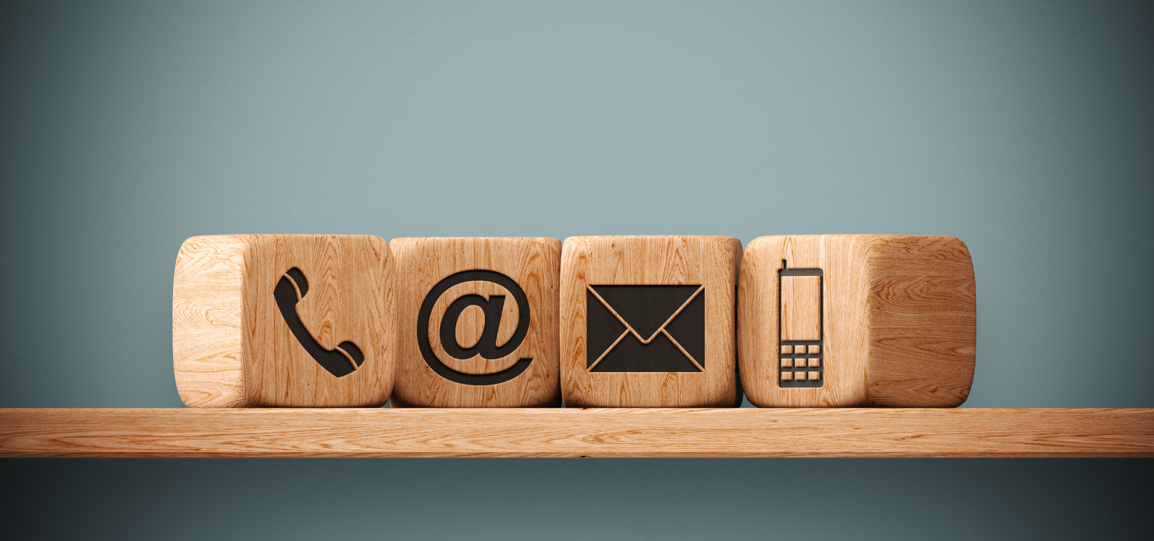 Holzwürfel mit Telefon-, E-Mail- und Handysymbolen