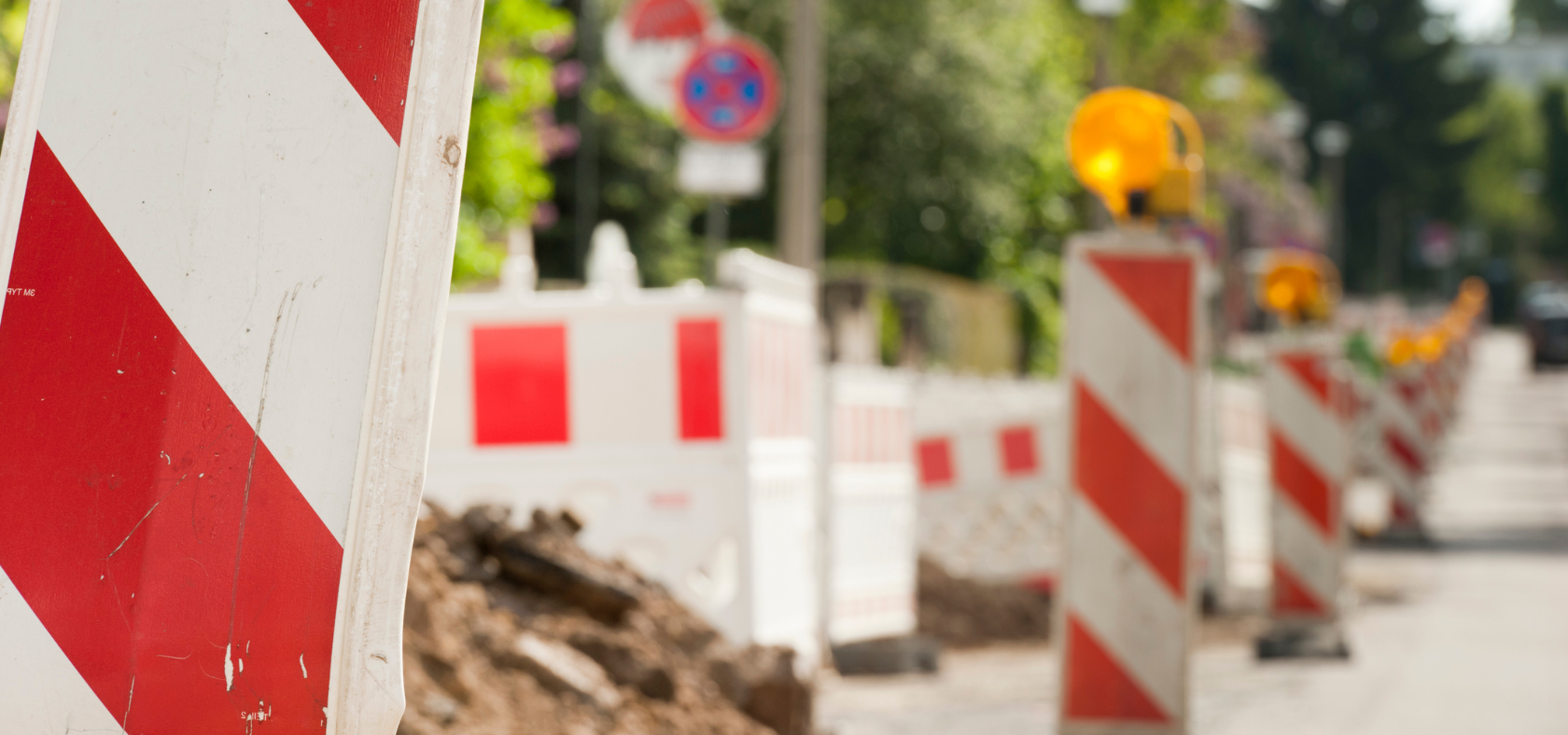 Am Straßenrand aufgereihte Baustellenabsperrungen