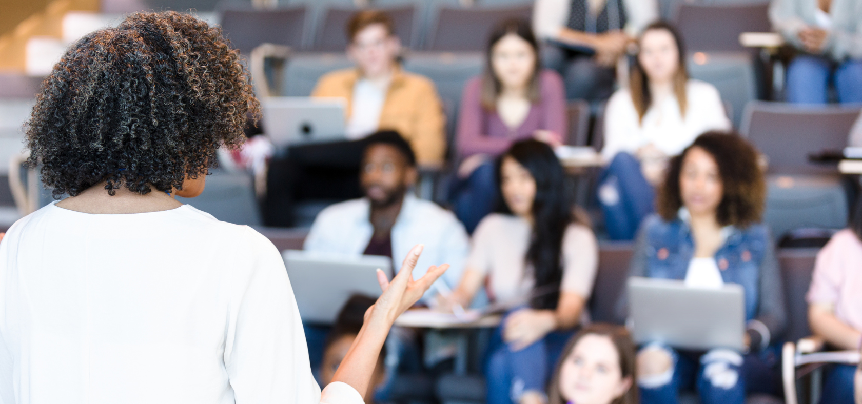 Frau hält Vorlesung im Hörsaal einer Hochschule