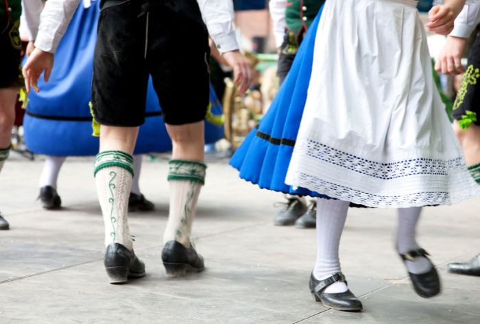 Tanzende Beine von Mädchen und Jungen in Tracht