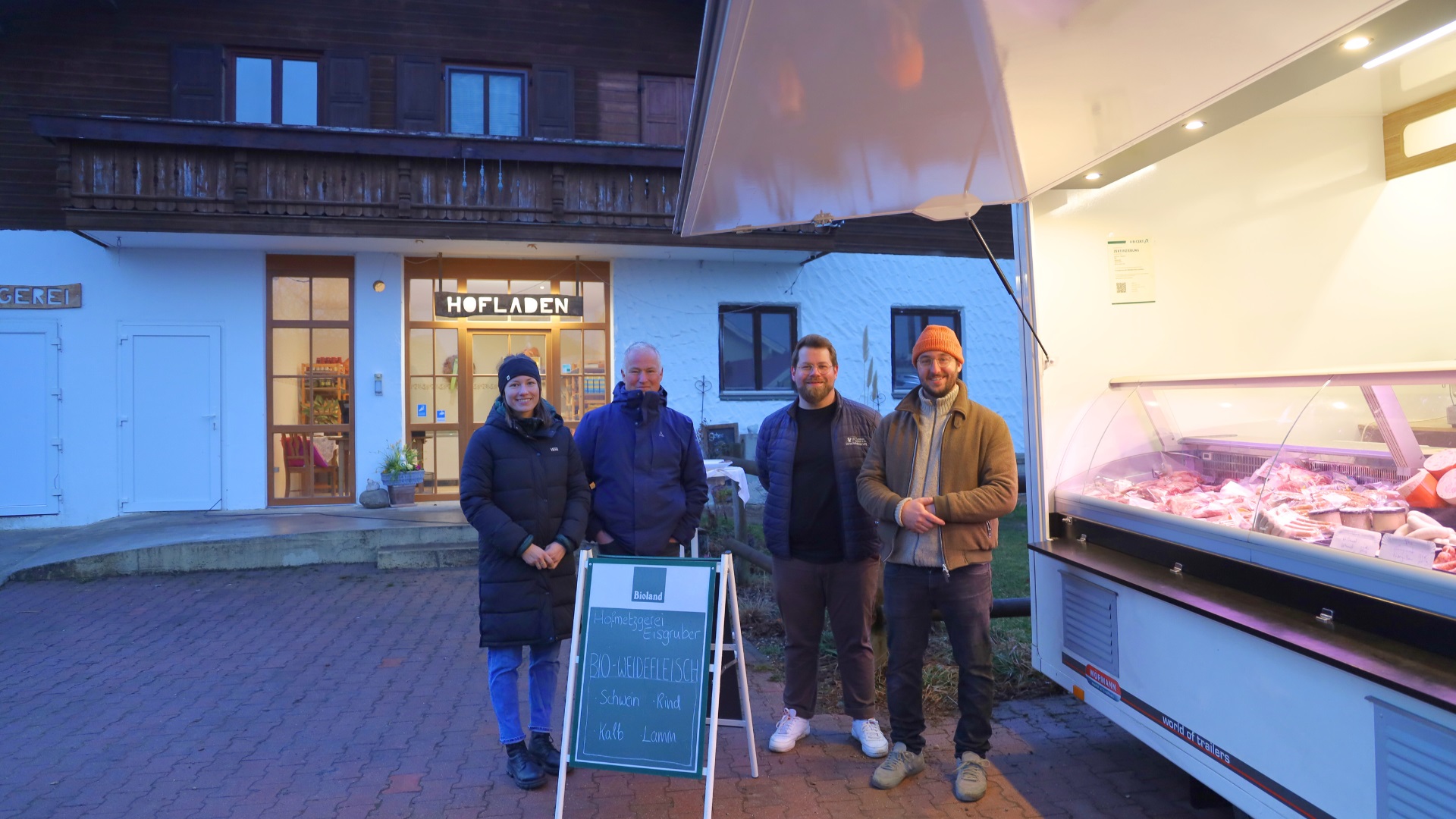 .l.n.r. Lena Koch (Projektmanagerin der Öko-Modellregion Mühldorfer Land), Michael Rittershofer (Geschäftsführer der Öko-Modellregion Mühldorfer Land), Thomas Perzl (Wirtschaftsförderer des Landkreises Mühldorf a. Inn), Franz Eisgruber (Biohof Eisgruber) vor dem geförderten Verkaufwagen und dem Hofladen der Familie Eisgruber