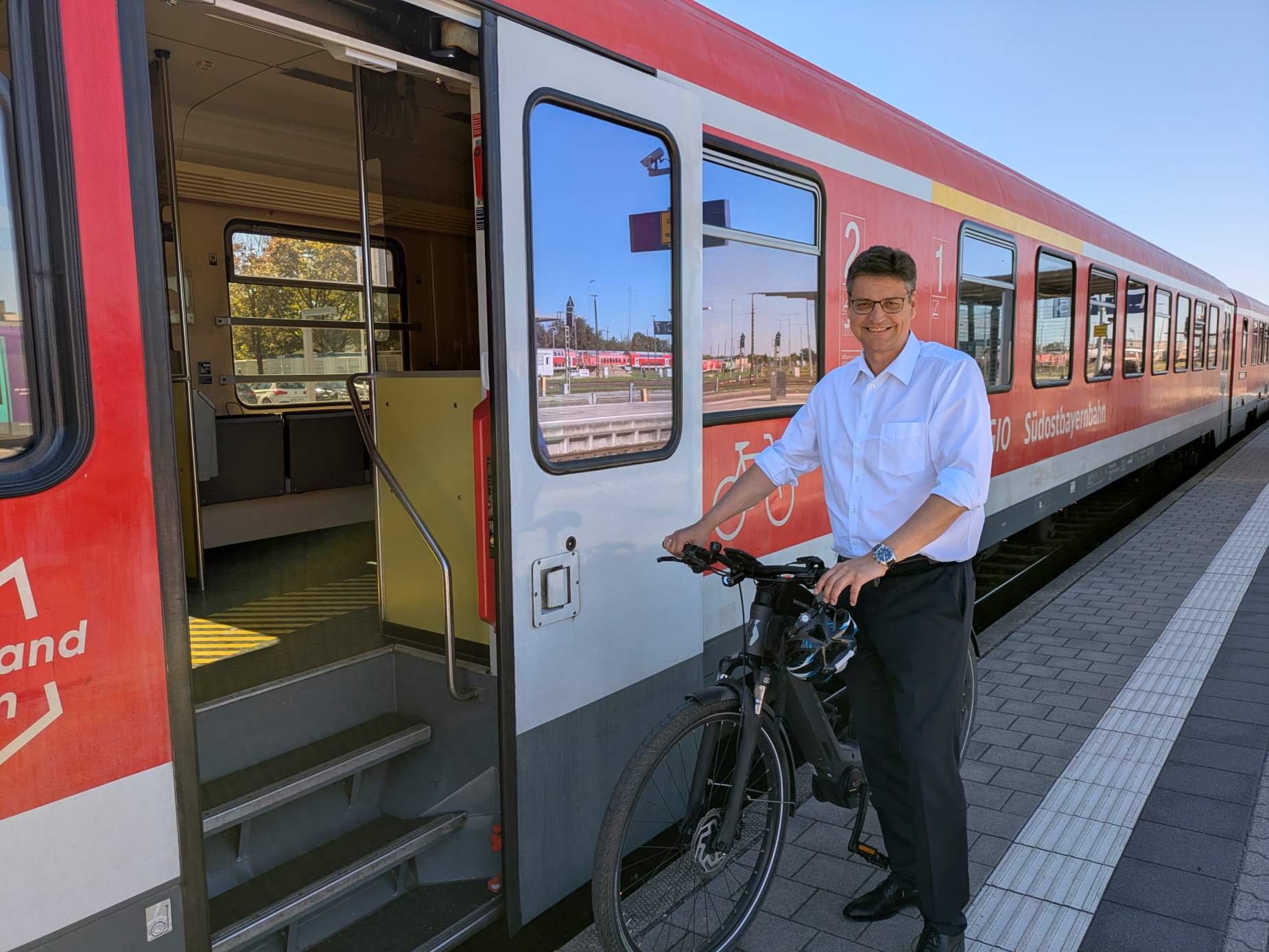 Landrat Max Heimerl mit Fahrrad vor einem Zug