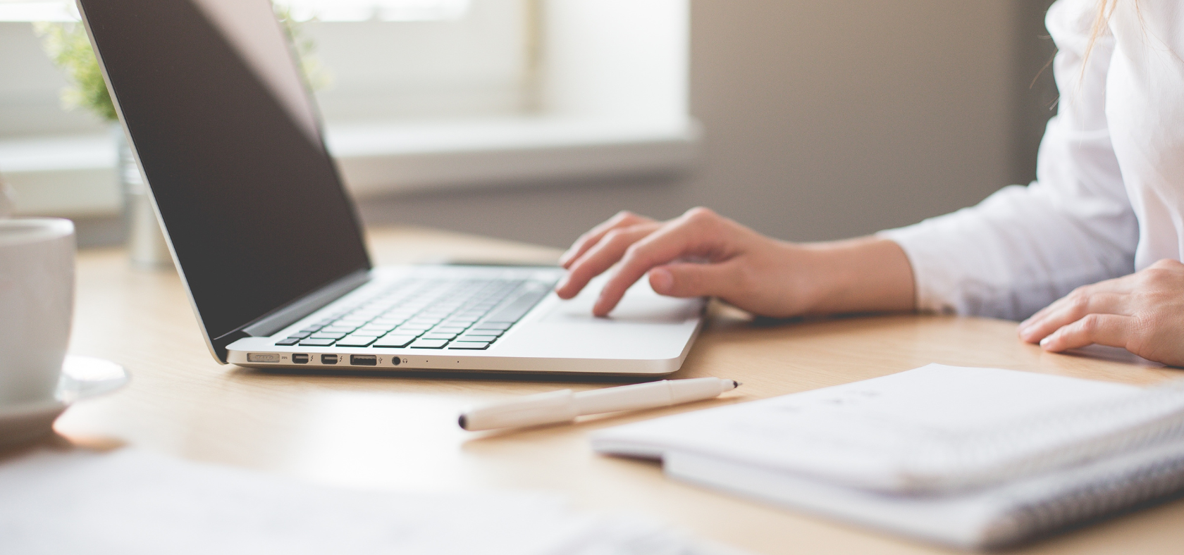 Laptop mit Stift und Block